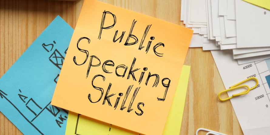 A post-it note with the words "Public Speaking Skills" written on it.