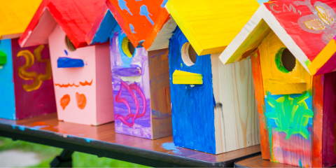 Colourful birdhouses placed on a table.