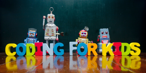 'Coding for Kids' spelt out using letters with robots standing behind it.