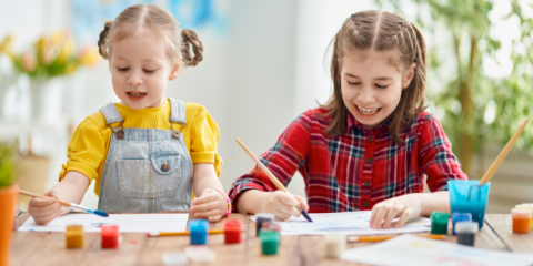 Two kids painting a picture.