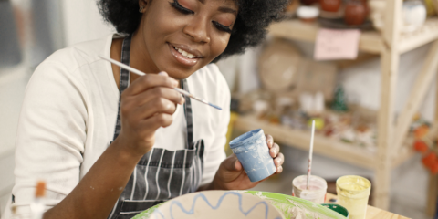 Black woman painting pottery 