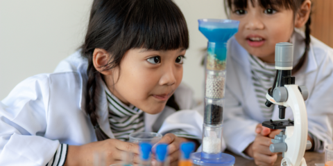 Two girls using a microscope 