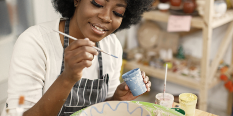 Black woman painting pottery