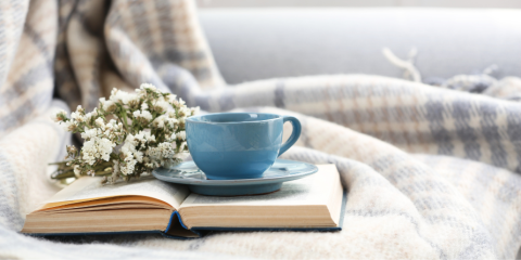 Teacup sitting atop an open book.