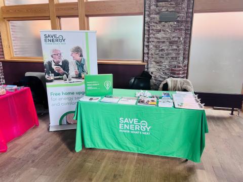 Green table with free flyers and resources on display, representing the Ontario Save Energy program.