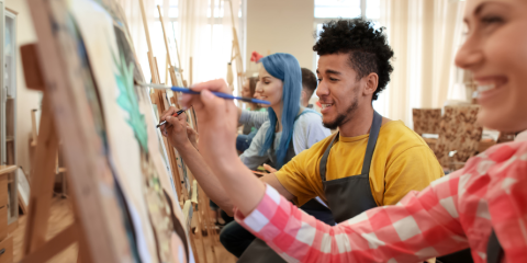 Smiling individuals painting.