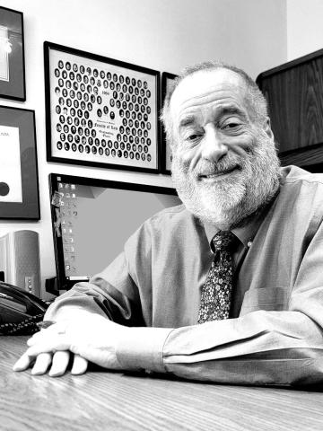 black and white photo of a man sitting at a desk