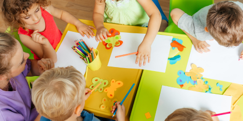 Kids colouring and writing on paper