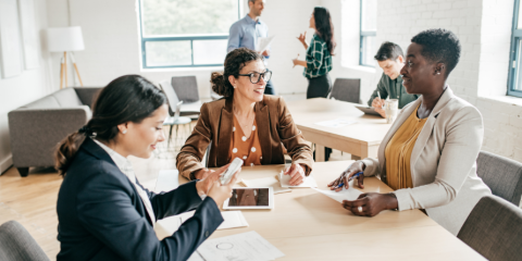 Group of smiling adults working on taxes. 