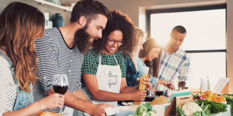 People gathered around a table, cooking together. 