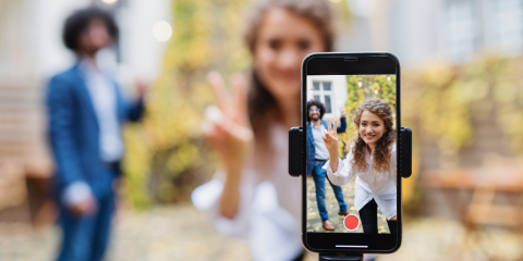 Two people recording a video on their phone. 