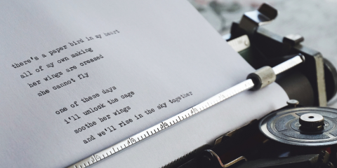 Typewriter printing text on a sheet of paper. 