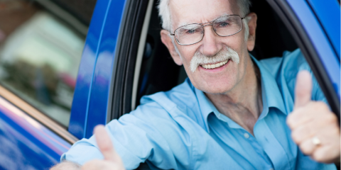 Smiling senior man in the car with his thumbs up. 