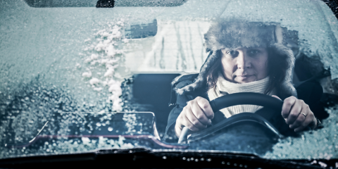 Person driving behind an icy windshield. 