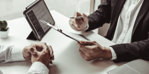 Two people speaking at a table. 