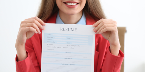 Smiling woman holding a resume. 