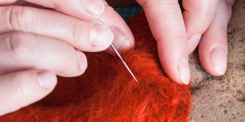 Close-up on hands working on a felting project. 