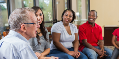 Two men, two women, having a lively conversation in a circle. 