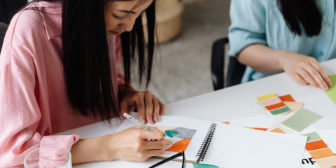Young girl with art supplies at a table. 