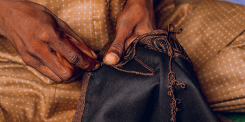 Close-up of hands sewing a piece of fabric. 