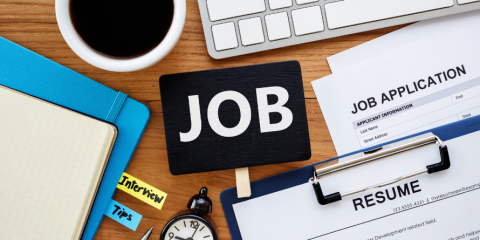 'Job' on a chalkboard, other office items on a desk.