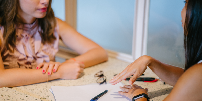 two women in discussion at a desk