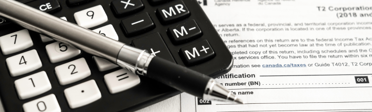 pen on top of calculator beside a Canadian CRA income tax return form