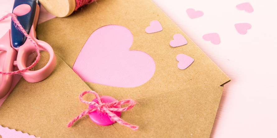 Pink heart cut outs on a table.