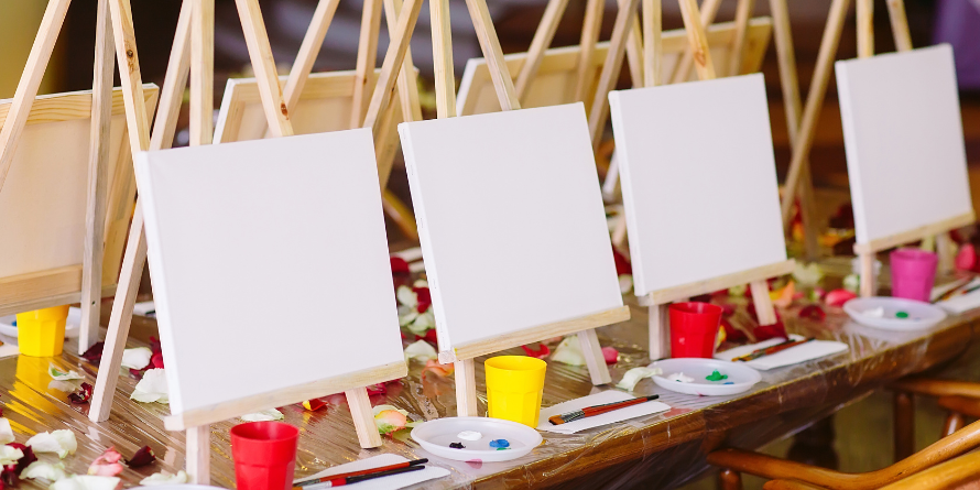 Blank canvases on a table with paint.