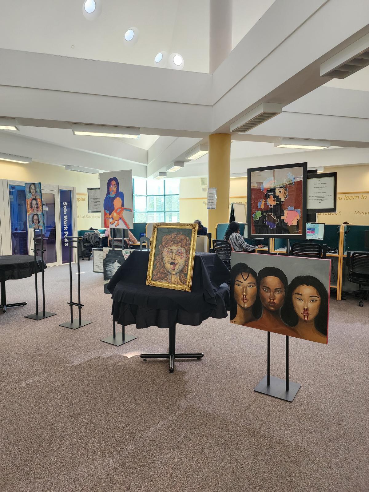 Paintings displayed on stands at the library