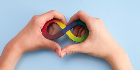 Neurodivergent symbol in a heart in a child's hands