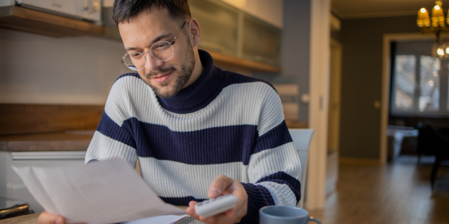 Young man with paper and calculator. 