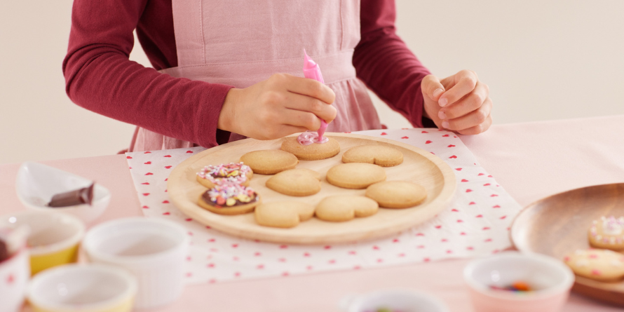 Woman decorating cookies.