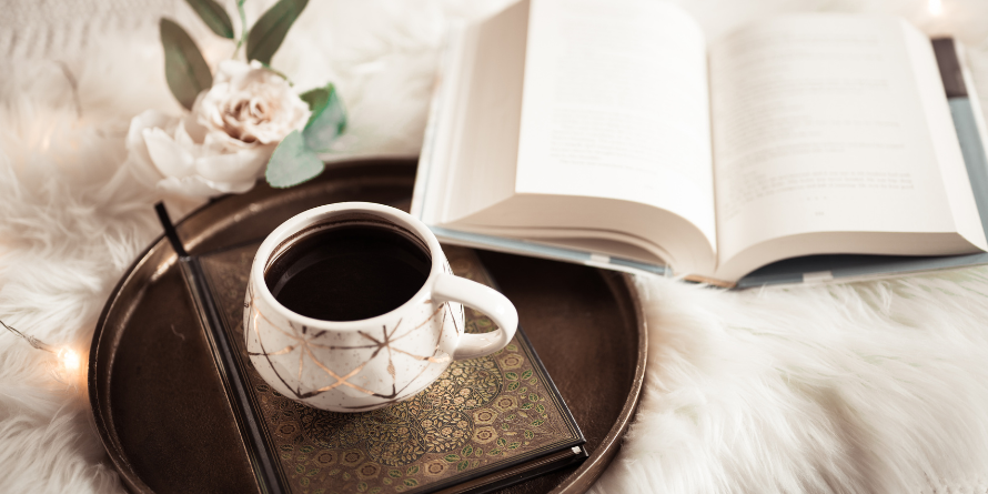 Teacup beside an open book.