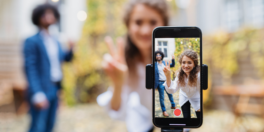 Two people recording a video on their phone. 