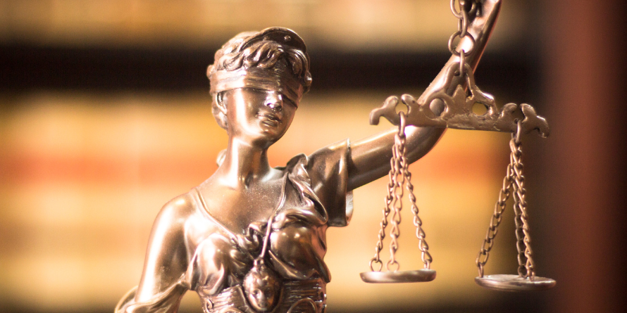 Bronze statues of woman holding scales. 