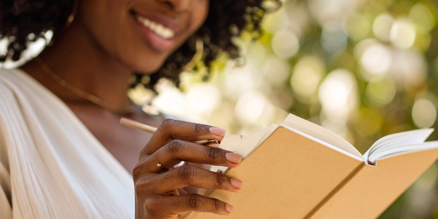 Smiling woman writing in a journal. 